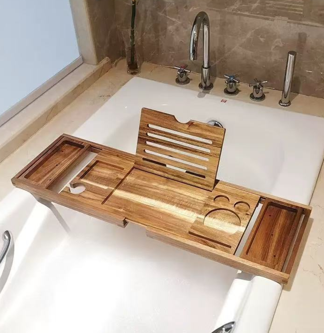 Acacia wooden bath caddy with expandable arms across a freestanding tub